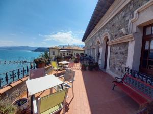 an outdoor patio with tables and chairs and the water at Hotel Eutimio in Lastres