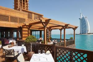 a restaurant with a balcony overlooking the ocean at Jumeirah Dar Al Masyaf in Dubai