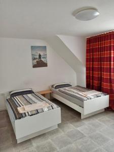 2 letti in una camera con tenda rossa di Apartments zum stillen Winkel a Niederbreitbach