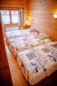 two beds in a room with wooden walls at Le Mont Blanc (Gite Des Alpes) in La Giettaz +12 photos