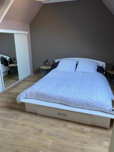 a bed with a blue comforter in a bedroom at La Petite Maison in Saint-Nicolas-du-Pélem +2 photos