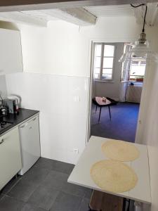 a kitchen with a white counter and a table at Appartement cosy rue Sainte Madeleine in Strasbourg +19 photos