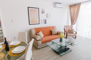 ein Wohnzimmer mit einer Couch und einem Glastisch in der Unterkunft Apartmani Veselinović in Vrnjačka Banja