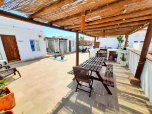 a patio with benches and a wooden pergola at The RooF Garden - Downtown TARIFA in Tarifa