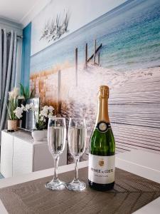 een fles champagne en twee wijnglazen op een tafel bij Studio Blue Cocoon Westende in Middelkerke