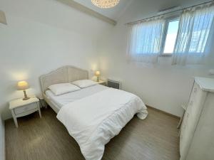 ビスカロッスにある302 RÉSIDENCE ANTINEA -016の白いベッドルーム(白いベッド1台、テーブル2台付)