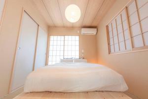 duże łóżko w pokoju z dużym oknem w obiekcie 南熱海あじろハウス w mieście Atami
