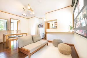 sala de estar con sofá y mesa en 南熱海あじろハウス en Atami