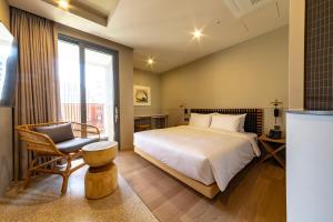 a bedroom with a bed and a chair and a window at Hound Garden&Terrace Hotel in Busan +28 photos