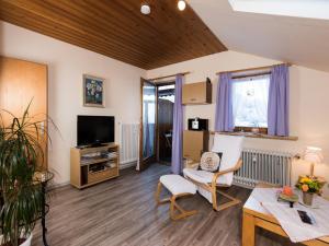 sala de estar con TV, silla y mesa en Ferienwohnung Tichy, en Berchtesgaden