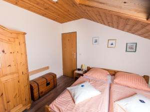 two twin beds in a room with wooden ceilings at Ferienwohnung Tichy in Berchtesgaden