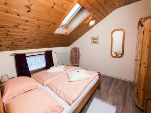 two beds in a bedroom with a wooden ceiling at Ferienwohnung Tichy in Berchtesgaden