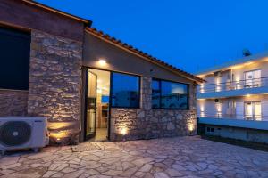 a house with a stone facade at night at Georgia Apartments in Kypseli