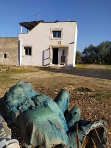 マルッジョにあるIl rifugio dell'Artistaの白い建物の前の青い岩
