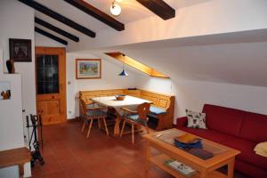 Una sala de estar con un sofá rojo y una mesa. en Apartment Watzmannblick, en Berchtesgaden