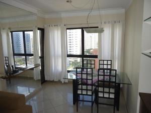 a dining room with a table and some windows at Portal dos Navegantes Apartment in Recife
