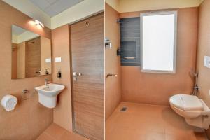 a bathroom with a toilet a sink and a shower at FabHotel Nestlay Rooms Airport in Chennai