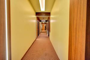a corridor of a hotel with yellow walls and a long hallway at FabHotel Nestlay Rooms Airport in Chennai
