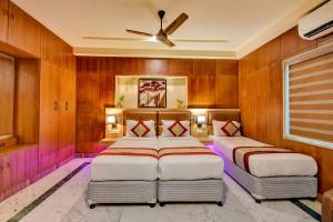 a hotel room with two beds and two lamps at FabHotel Nestlay Rooms Airport in Chennai