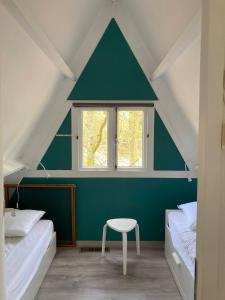 a room with two beds and a table and a window at Chalet 42 - Durbuy in Durbuy +13 photos