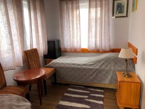 シャーロシュパタクにあるBorostyán 20 Vendégházのベッドルーム1室(ベッド1台、椅子、テーブル付)