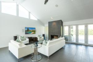 a living room with white furniture and a fireplace at Villa Tranquilo home in Palm Springs