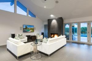 een woonkamer met 2 witte banken en een open haard bij Villa Tranquilo home in Palm Springs