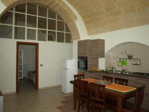 a kitchen with a table and a white refrigerator at La Rosa dei Sassi in Matera