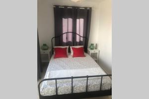 a bedroom with a black and white bed with red pillows at Casa El Castellet en Polop. in Polop