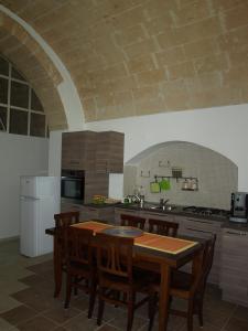 a kitchen with a table and chairs and a kitchen with a refrigerator at La Rosa dei Sassi in Matera