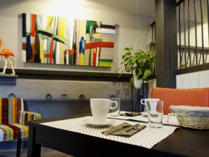 a dining room table with a white table cloth and glasses at Les Prémontrés in Falaise