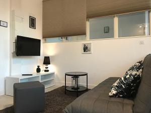 a living room with a couch and a table at Appart'hôtel Chambrappart in Falaise