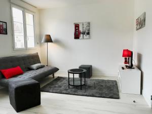 a living room with a couch and a table at Appart'hôtel Chambrappart in Falaise