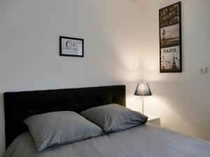 1 cama con 2 almohadas y 1 lámpara en el dormitorio en Appart'hôtel Chambrappart en Falaise