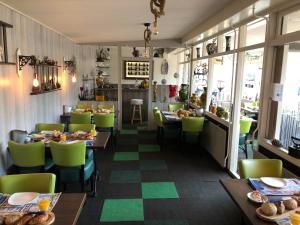 une salle à manger avec des tables et des chaises vertes dans l'établissement Pension Even Buiten, à Burgh-Haamstede