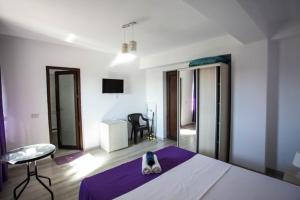 a bedroom with a bed with a purple blanket at Villa Sunset Beach Mamaia Nord in Mamaia Sat/Năvodari