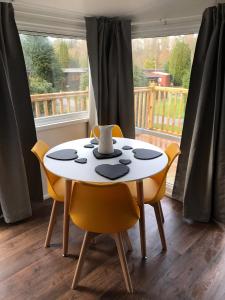 a table and chairs in a room with a window at Daffodil Lodge in Builth Wells