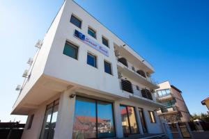 a tall white building with windows on the side of it at Villa Sunset Beach Mamaia Nord in Mamaia Sat/Năvodari