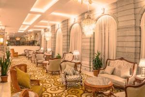 a lobby with chairs and tables and a chandelier at The Grand Palace Hotel in Addis Ababa