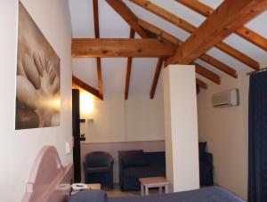 a living room with a blue couch and wooden ceilings at Lo Scoiattolo in Massino Visconti