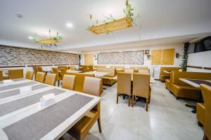 a dining room with tables and chairs and a brick wall at BM Plaza in Bakuriani