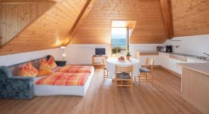 a living room with a bed and a table at Apartments Herrnhofer in Caldaro