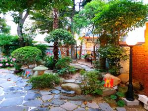 Gallery Family Hotel في موكبو: حديقة فيها اشجار وممشى حجري