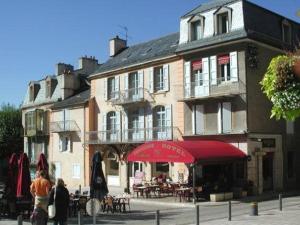 ein großes Gebäude mit Tischen und Stühlen davor in der Unterkunft Logis Hôtel Restaurant Le Drakkar in Mende