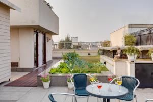 a patio with a table and chairs on a balcony at Ishatvam-4 BHK Private Serviced apartment with Terrace, Anand Niketan, South Delhi in New Delhi