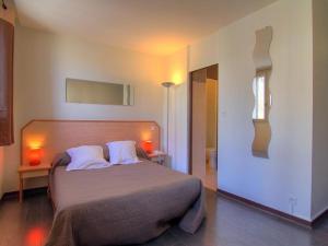 a bedroom with a large bed with two white pillows at Logis Hôtel Restaurant Le Drakkar in Mende