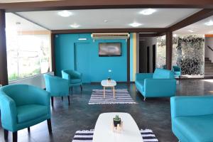 a waiting room with blue chairs and a table at Hotel Montana by CPH in Villa Carlos Paz