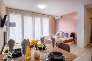 a living room with a dining table and a bedroom at MyFlat Siófok Beach Wellness Apartment in Siófok
