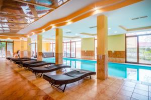 a swimming pool with a row of benches next to it at MyFlat Siófok Beach Wellness Apartment in Siófok