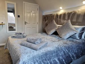 Un dormitorio con una cama azul con toallas. en The Rufford Hotel en Skegness